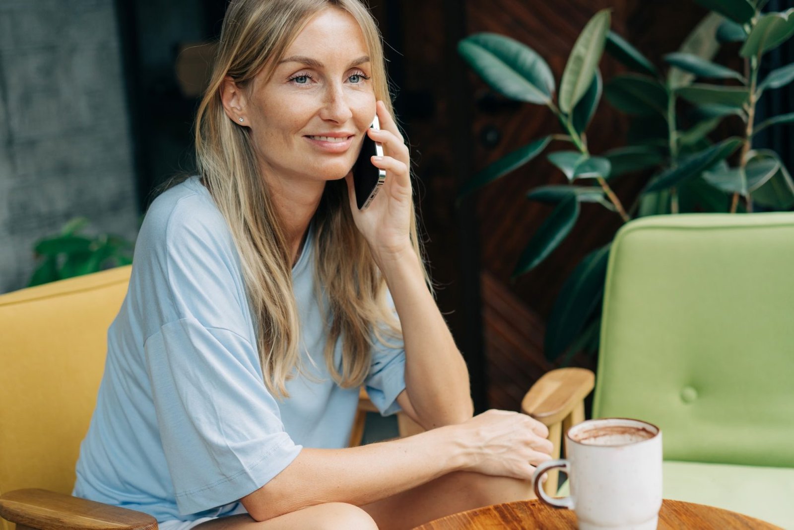 Portrait of a woman talking on the phone while sitting in a coffee house.